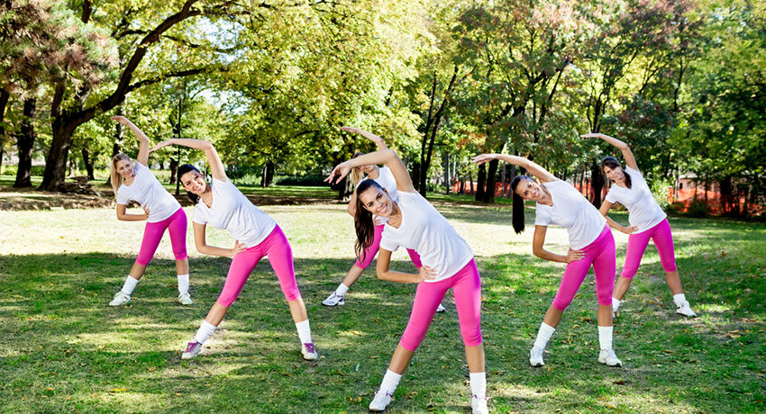 Working out in a park is fun! But we promise everyone won;t be in the same outfit. Group fitness photo via Shutterstock.