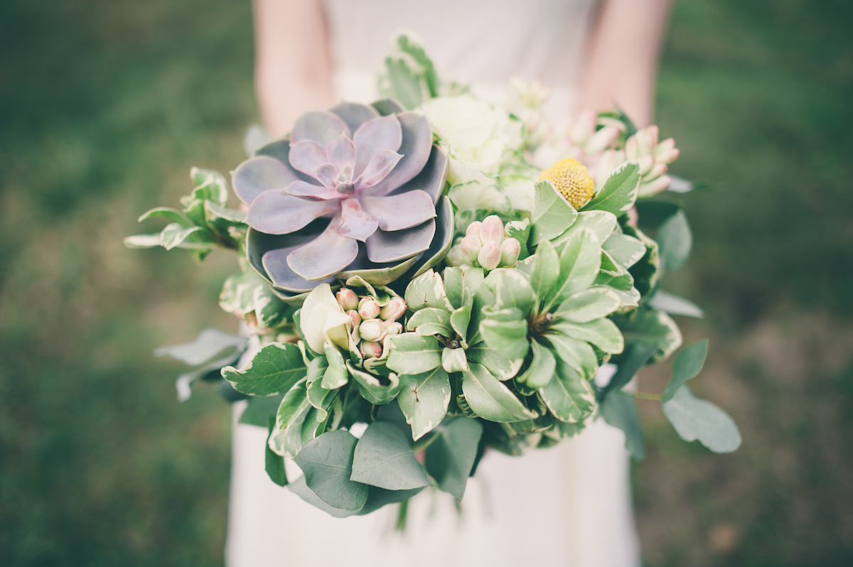 Bride holding wedding bouquet of succulents via Shutterstock