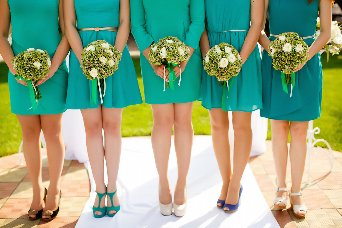 Row of bridesmaids with bouquets at wedding ceremony via Shutterstock