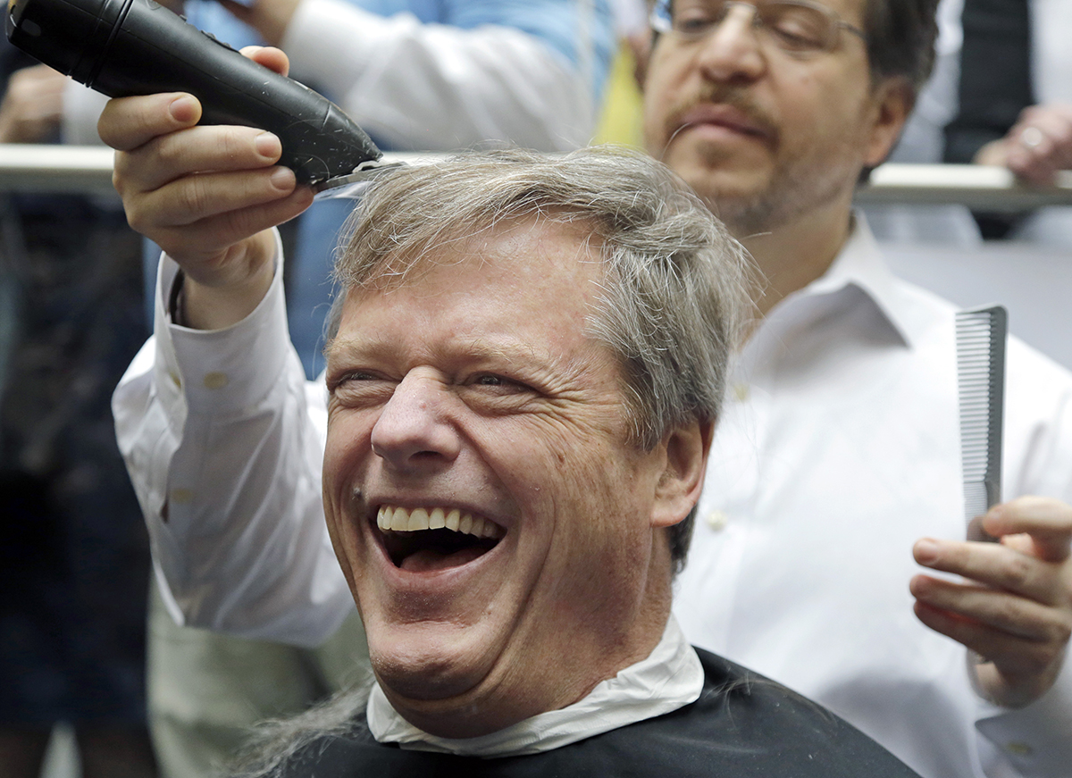 Massachusetts Gov. Charlie Baker reacts as he gets a buzz cut during a fundraising drive at Granite Telecommunications in Quincy, Mass., Tuesday, April 7, 2015, in support of the Dana-Farber Cancer Institute. Baker joined more than 500 company employees who shaved their heads to raise more than $3.5 million for cancer research. (AP Photo/Elise Amendola)