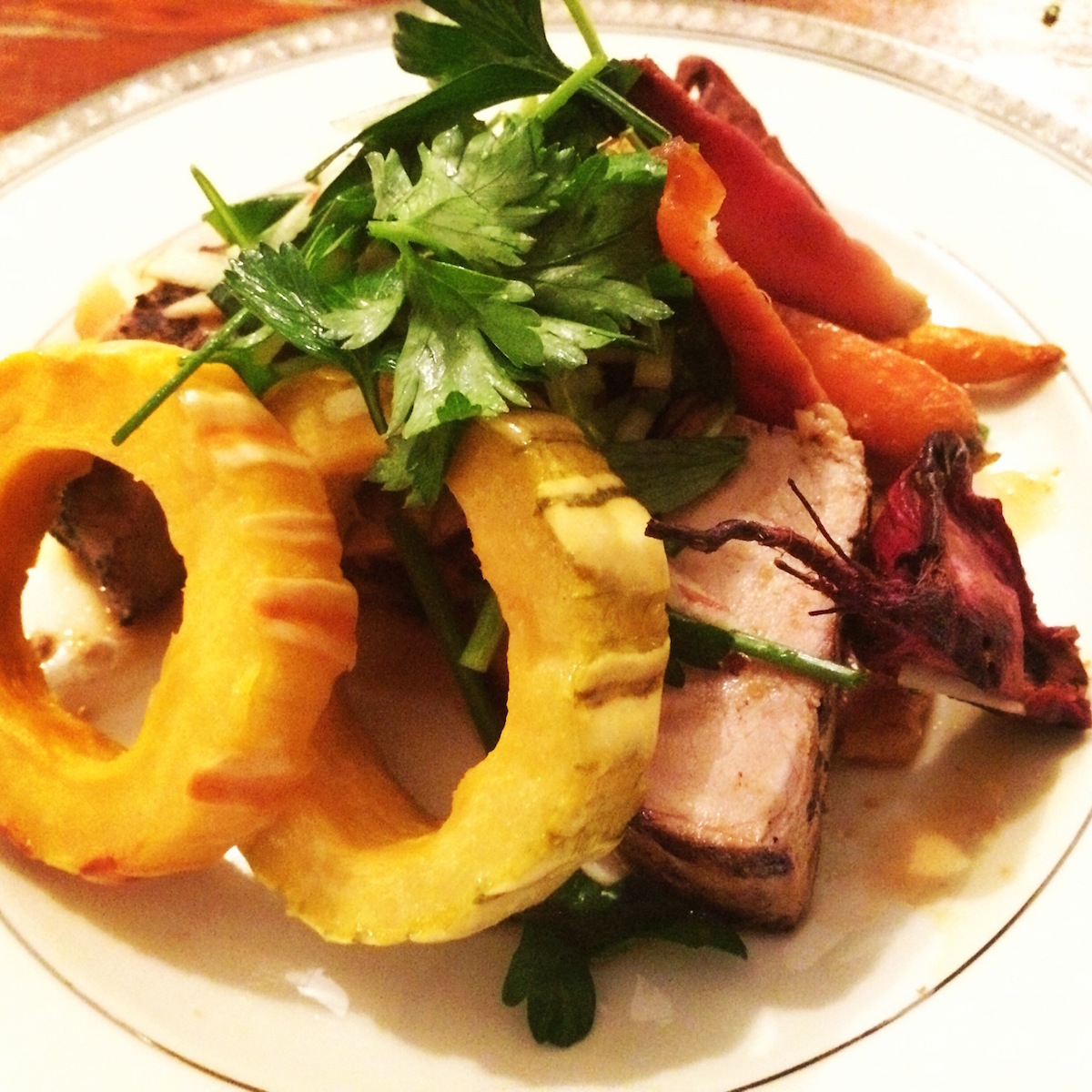Heritage Pork Tenderloin with Cider Mustard Demi Glace, Root Vegetable Ragu, Delicata Squash Rings and Herb Salad/Courtesy photo