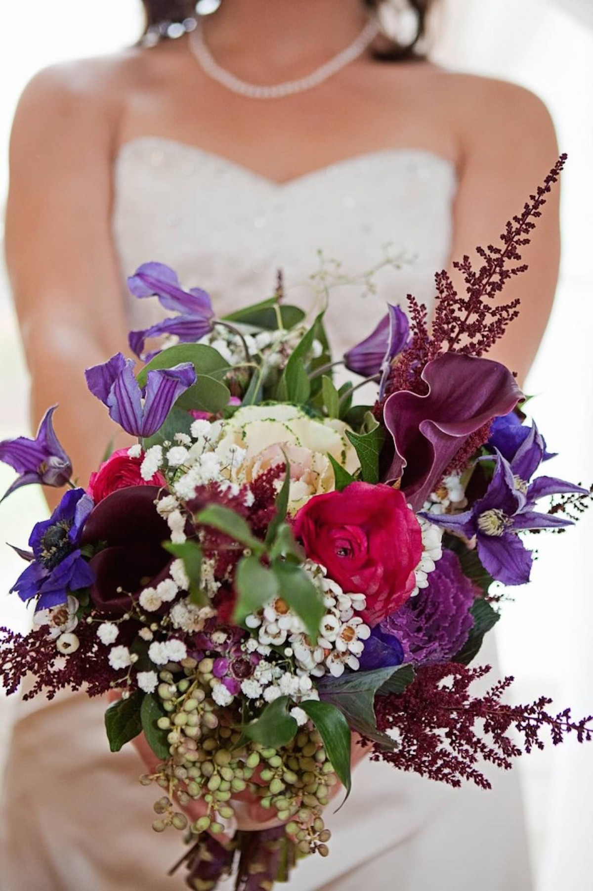 mini kale accented by ranunculus, waxflower, astilbe, calla lilies and purple clematis/Courtesy photo