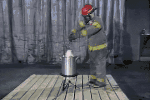 In lab tests, an asbestos-suited researcher starts an oil fire with a deep fryer at Underwriters Laboratories