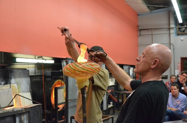 Two glassblowers work on a project as a class watches at Diablo Glass School.