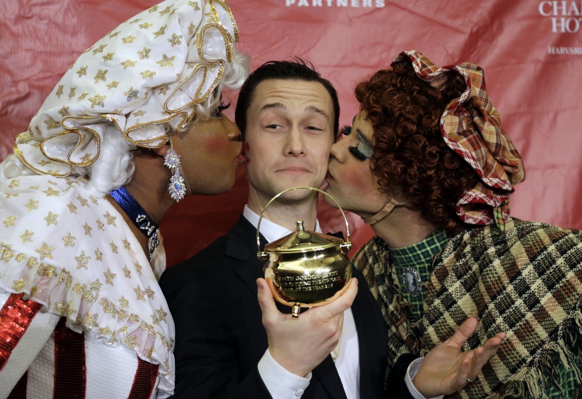 Joseph Gordon-Levitt is kissed by two Hasty Pudding actors in drag.