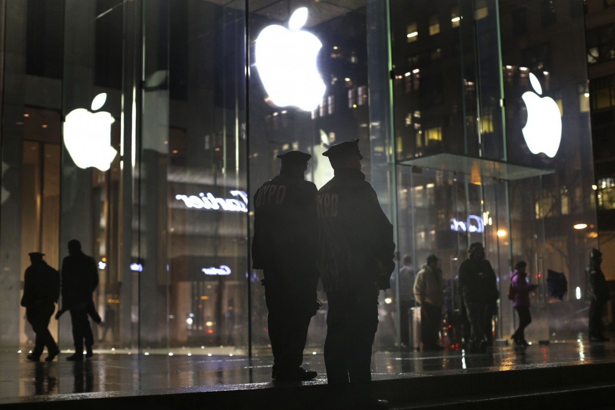 New York police officers stand outside the Apple Store on Fifth Avenue while monitoring a demonstration, Tuesday, Feb. 23, 2016, in New York. Protesters assembled in more than 30 cities around the world to lash out at the FBI for obtaining a court order that requires Apple to make it easier to unlock an encrypted iPhone used by a gunman in December's mass murders in California. (AP Photo/Julie Jacobson)