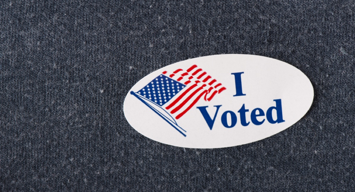 Closeup of an American "I voted" sticker placed on a navy shirt.