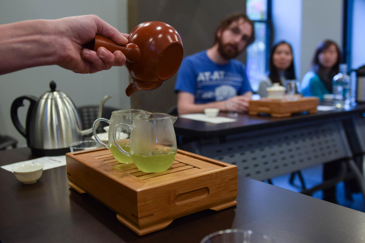 Scalise uses a Japanese Kyusu to pour Gyokuro, a seaweed-y tasting Japanese green tea, into two pitchers. The wooden contraption they’re sitting on is a tea boat, which holds water to rinse the equipment and catches any spills. / Photo by Lloyd Mallison