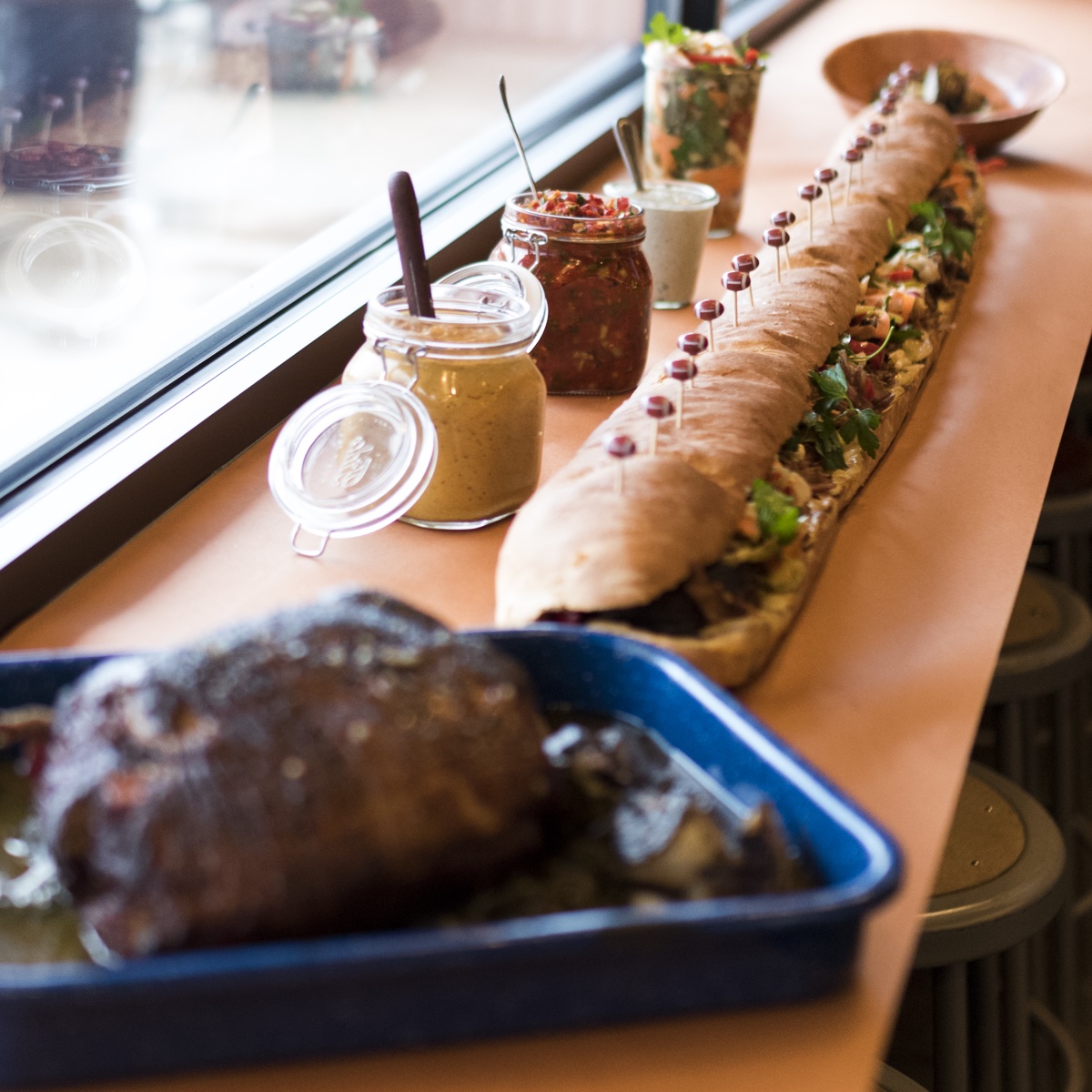 Roasted pork shoulder with fennel and broccoli rabe, Sweet Cheeks condiments, and a 5-Foot Pork Bomb