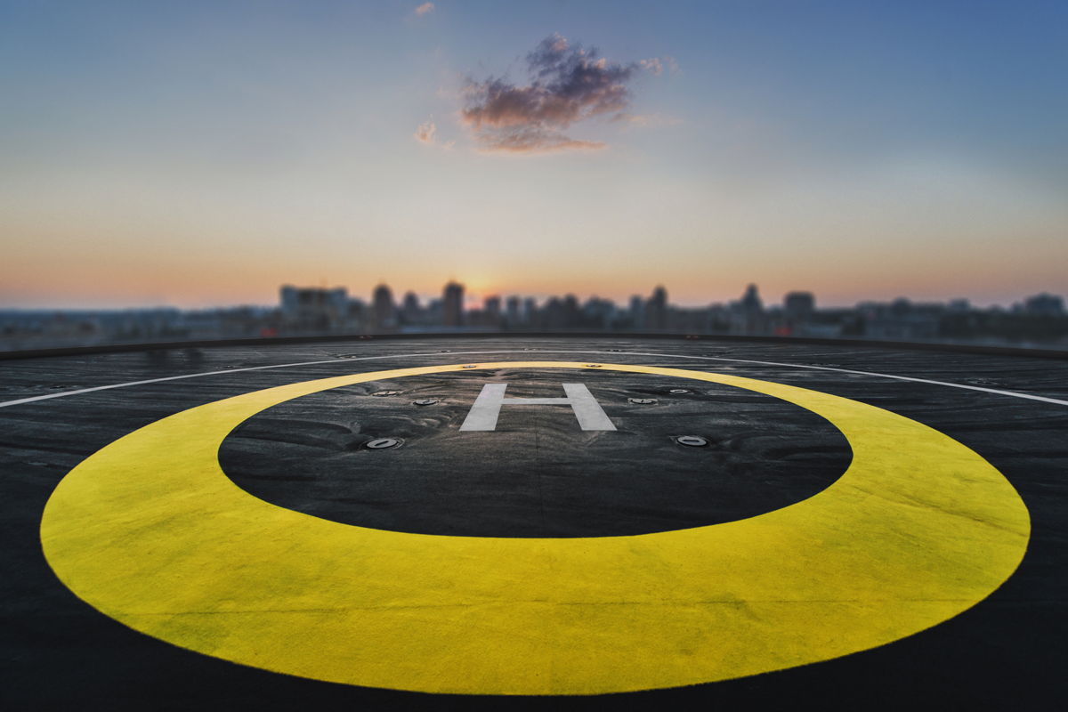 Helipad on the roof of a skyscraper after raining with cityscape view and sunset