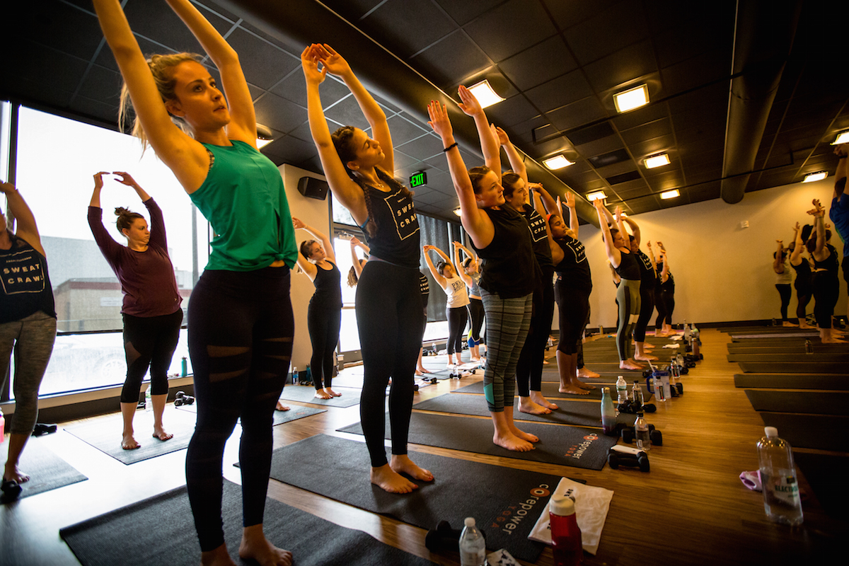 Women stretch during a workout at the 2016 Sweat Crawl