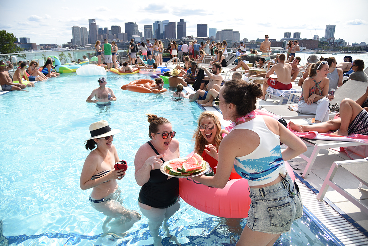 East Boston Oysters creative coordinator Grace Ghazey serves guests watermelon off a sliver platter at an EBO Pool Party in 2017