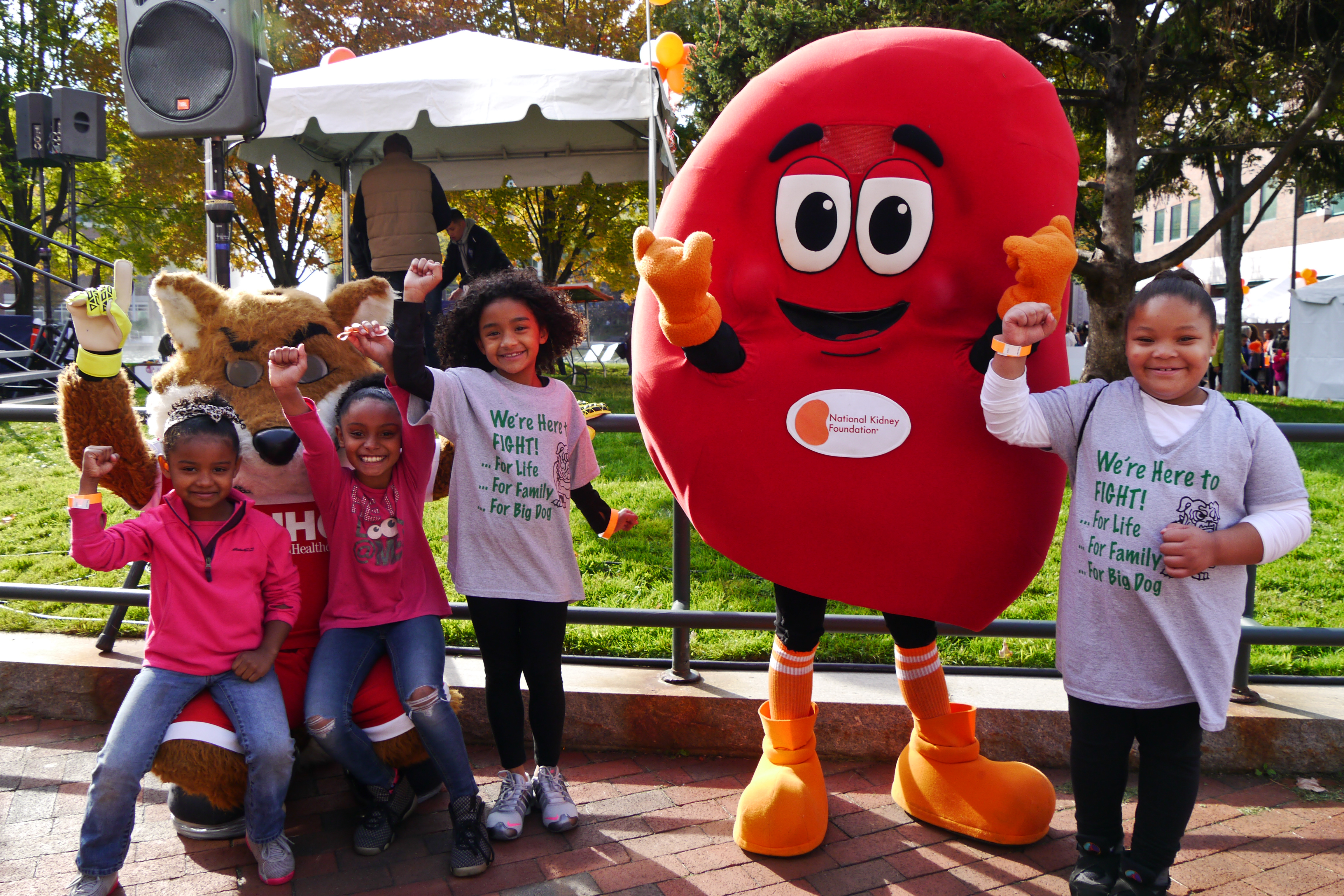 Children standing next to someone in a kidney costume