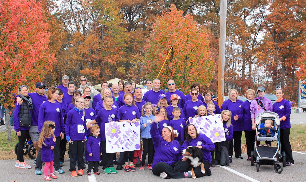 Walkers at Promises for Purple hold signs