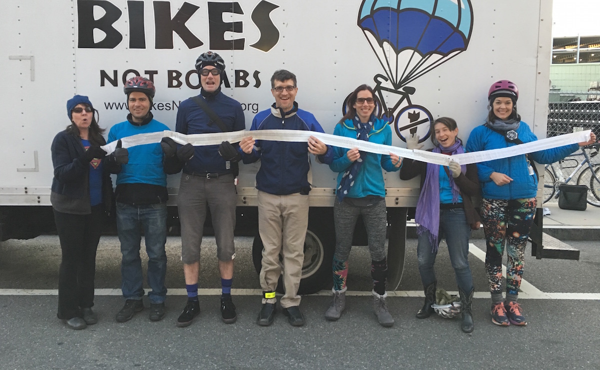 A group of cyclists hold a grocery store receipt