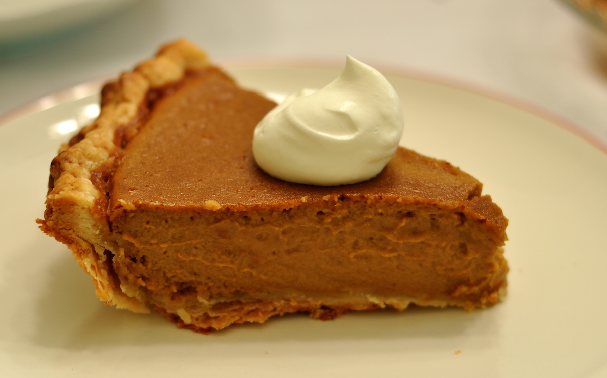 pumpkin pie slice with dollop of whipped cream