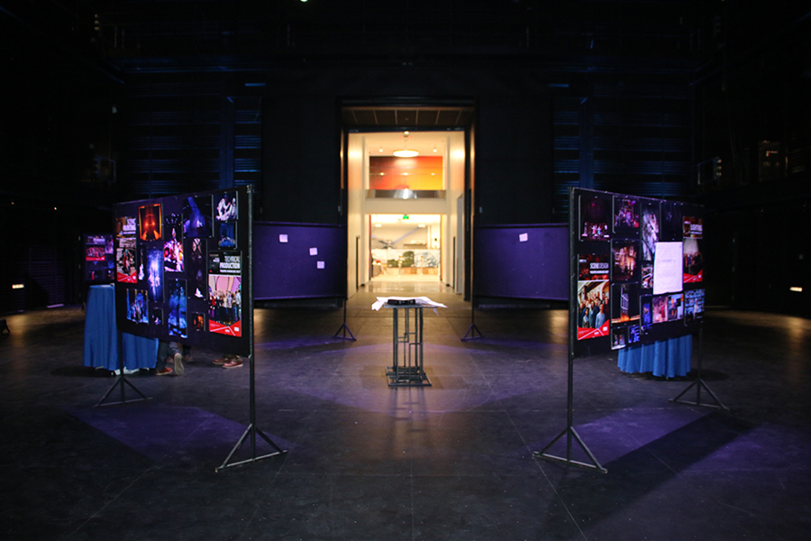 A dark theater with a few bulletin boards in the middle