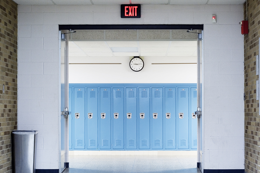 Blue lockers beneath a clock and an exit sign
