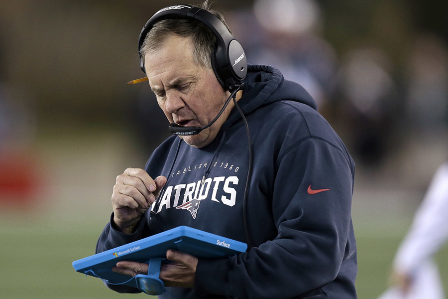 In this Dec. 6, 2015, file photo, New England Patriots head coach Bill Belichick studies a tablet device along the sideline during the first half of an NFL football game against the Philadelphia Eagles in Foxborough, Mass. Belichick said Tuesday, Oct. 18, 2016, that he's through using the sideline tablets, saying there isn't enough consistency in the performance of the devices. (