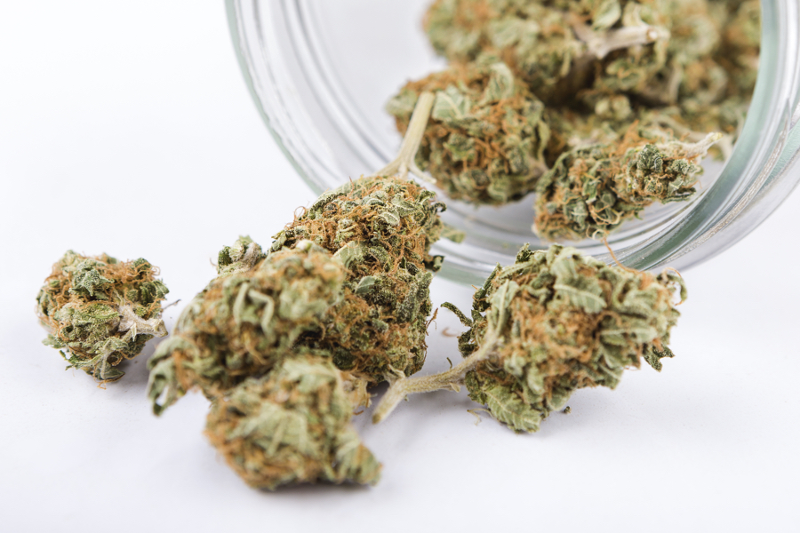 Marijuana buds on white background with jar
