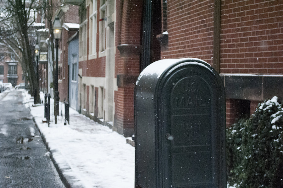 A snow-covered mailbox and brick building in Beacon Hill