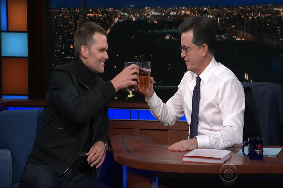 Tom Brady and Stephen Colbert clink beers