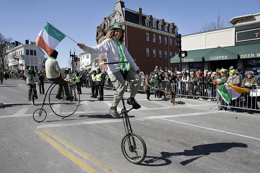 A member of the Cycling Murrays holds an Irish flag while riding a unicycle during the annual St. Patrick's Day parade, Sunday, March 18, 2018, in Boston. The city's 117th St. Patrick's Day Parade followed a shortened snow route used three of the past four years due to the buildup of snow from three recent nor'easters. 