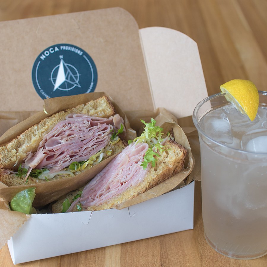 Noca Provisions' ham and Swiss sandwich with frisée and apple mostarda, and a house-made lemon lavender soda packed up for a picnic