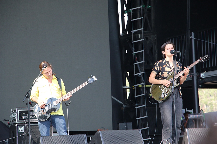 A pair of musicians with guitars play on stage