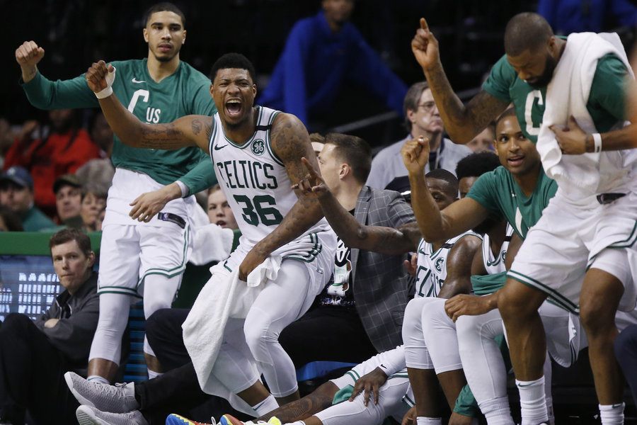 Boston Celtics players, from left, forward Jayson Tatum, guard Marcus Smart (36), forward Al Horford and forward Marcus Morris, far right, cheer from the bench during the fourth quarter of Game 1 of the NBA basketball Eastern Conference Finals against the Cleveland Cavaliers, Sunday, May 13, 2018, in Boston. The Celtics won 108-83. 