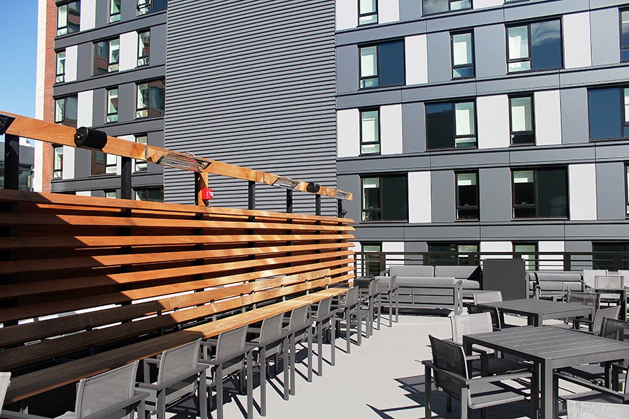 A lounge area and dining tables on the roof deck at Trillium Fort Point