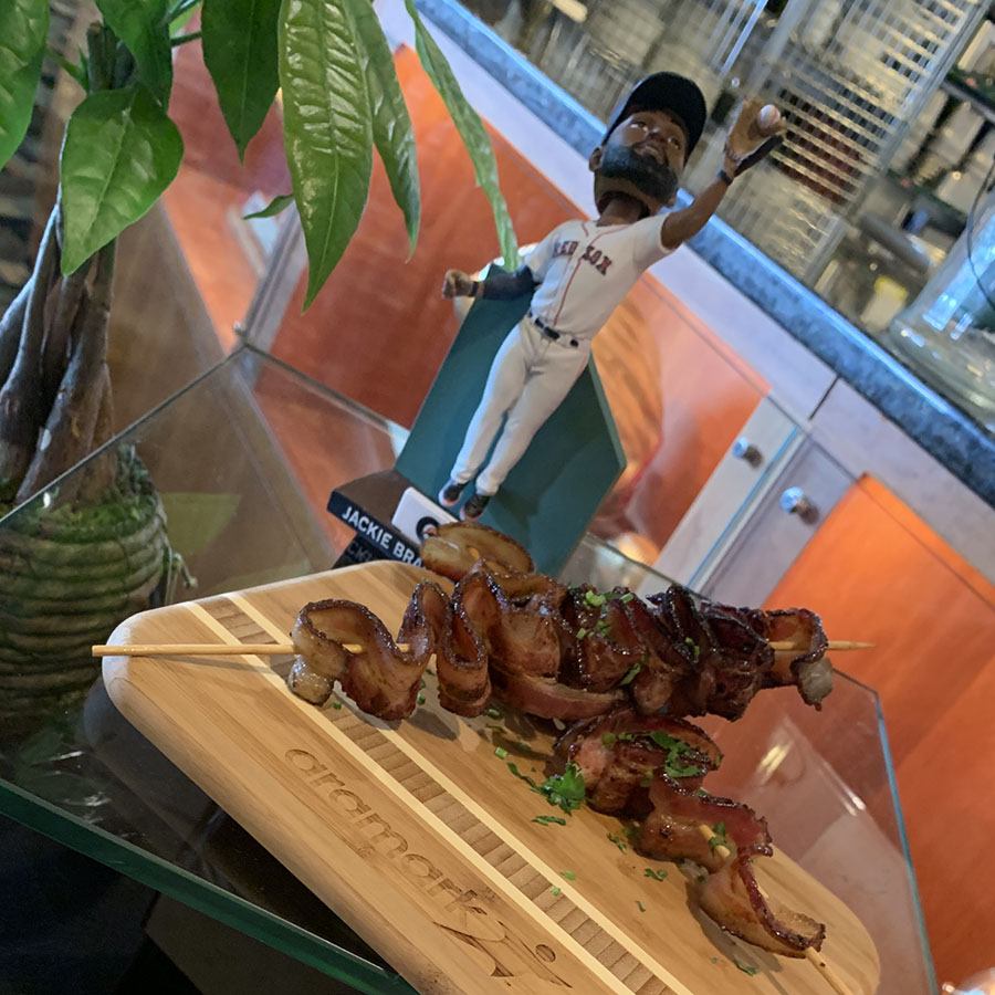 With a sweet Boston Lager-glaze, crispy bacon-on-a-stick is one of the more outrageous new snacks available at Fenway Park