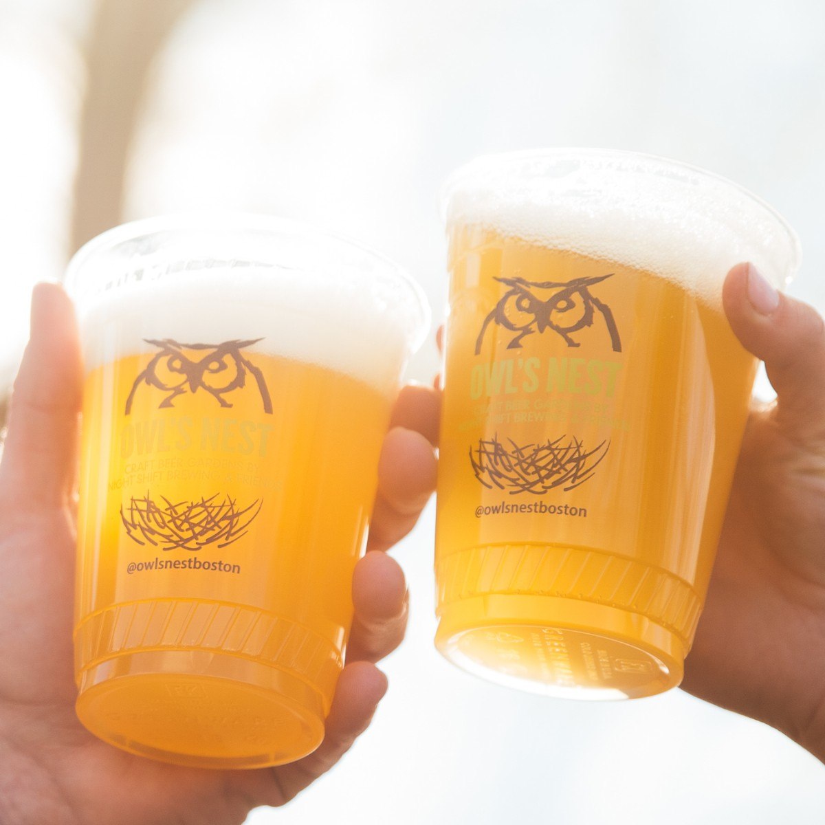 Two plastic pints of beer "cheers" at Night Shift Owl's Nest beer garden