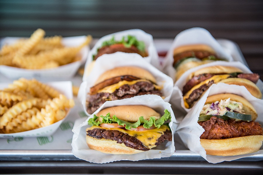 A tray of crinkle fries, burgers, and chicken sandwiches at Shake Shack