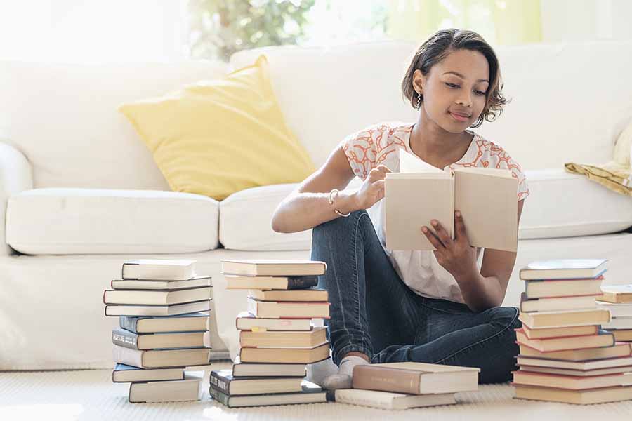 woman reading stack of books