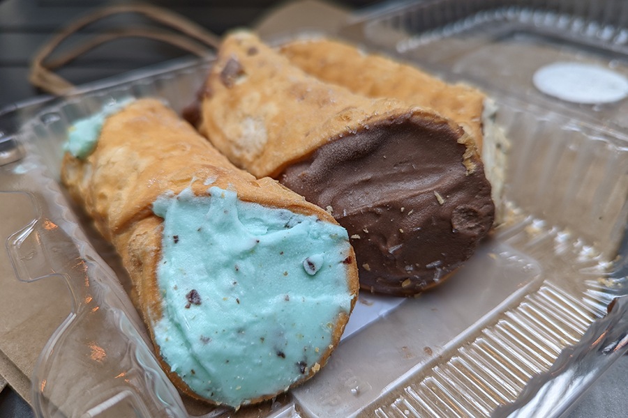 Two brioche shells are filled with ice cream, one with mint chips and the other with dark chocolate.