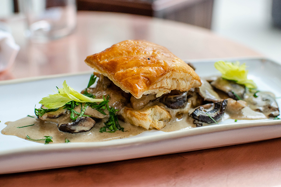 Mushrooms are stuffed between puff pastry, and the whole thing sits in a pool of light brown sauce.