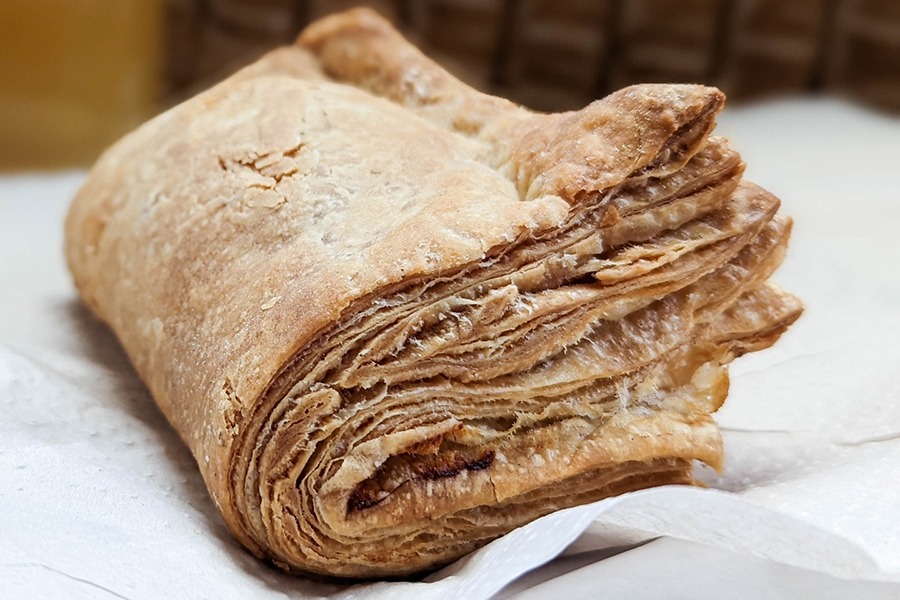 Layers of puff pastry are folded in half to form a pastry that almost looks like a book.