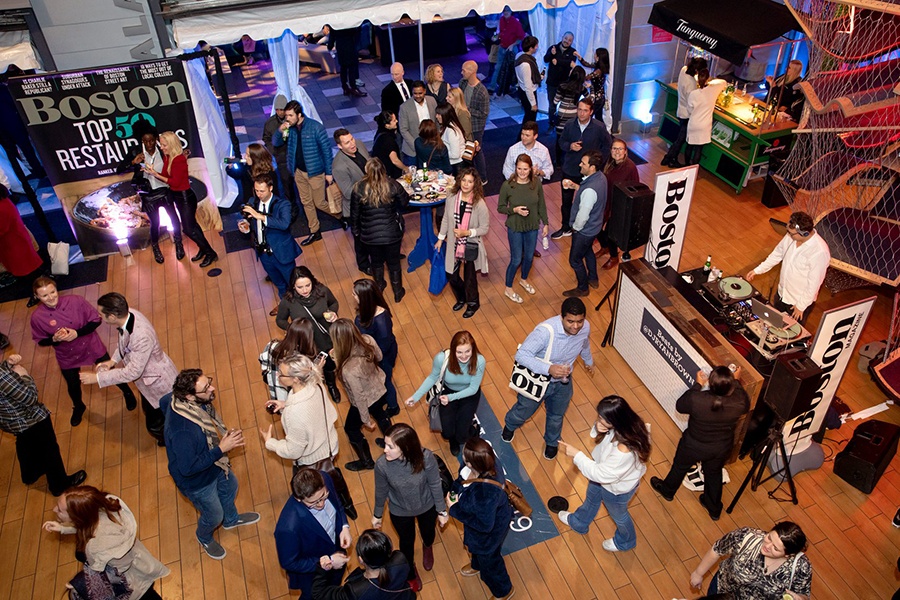 Overhead view of lots of casually dressed people at an event with Boston magazine branding visible throughout.