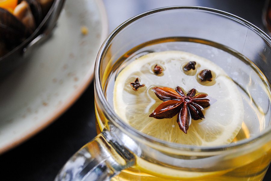 A close-up shot of a hot toddy topped with star anise and lemon.