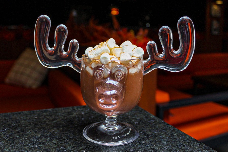 Hot chocolate topped with marshmallows in a moose-shaped mug.
