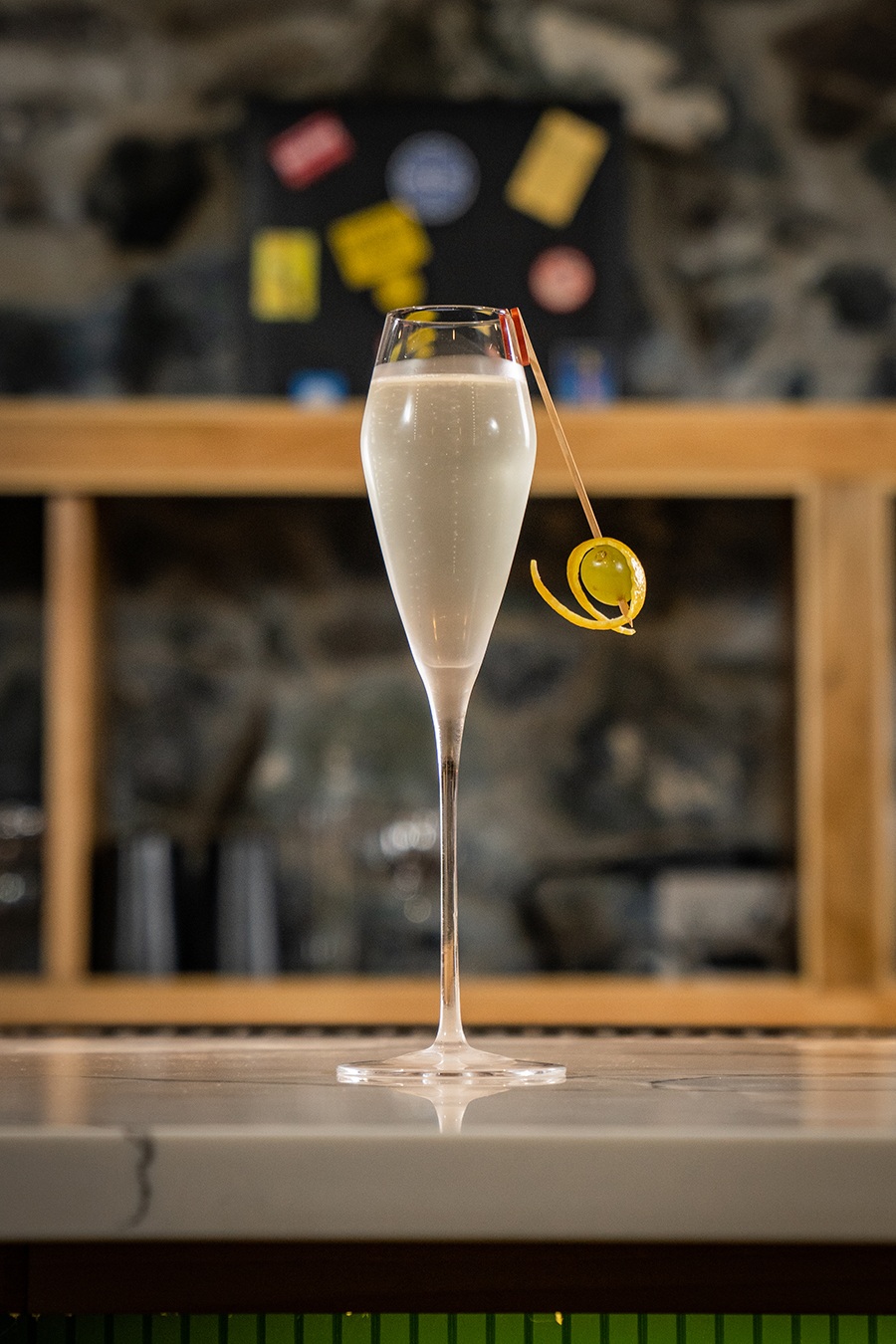 A cocktail that looks like Champagne is served in a tall, thin glass.