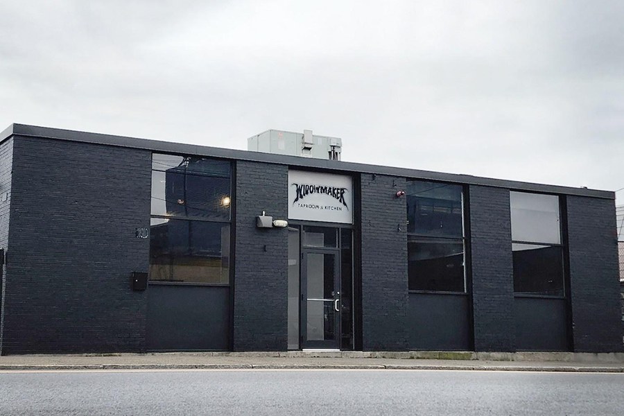 Exterior of a single-story, industrial-looking brick building painted black, with signage reading Widowmaker.