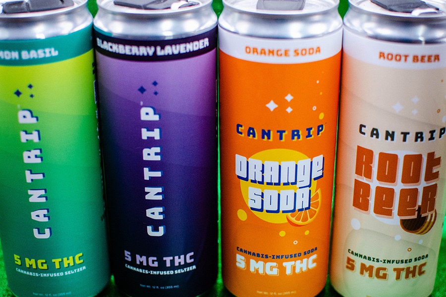 Four cans are labeled with Cantrip branding, each with a different flavor of seltzer or soda.