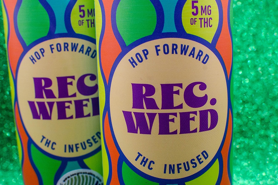 Two colorful cans say "Hop Forward Rec Weed THC Infused" and are displayed on a sparkly green background.