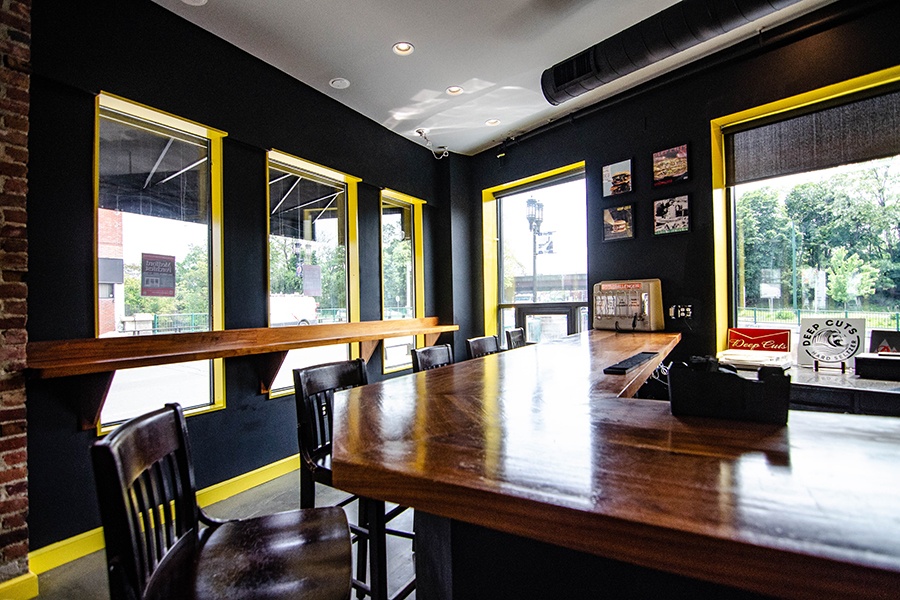 A glossy wooden bar with black walls with bright yellow accents.