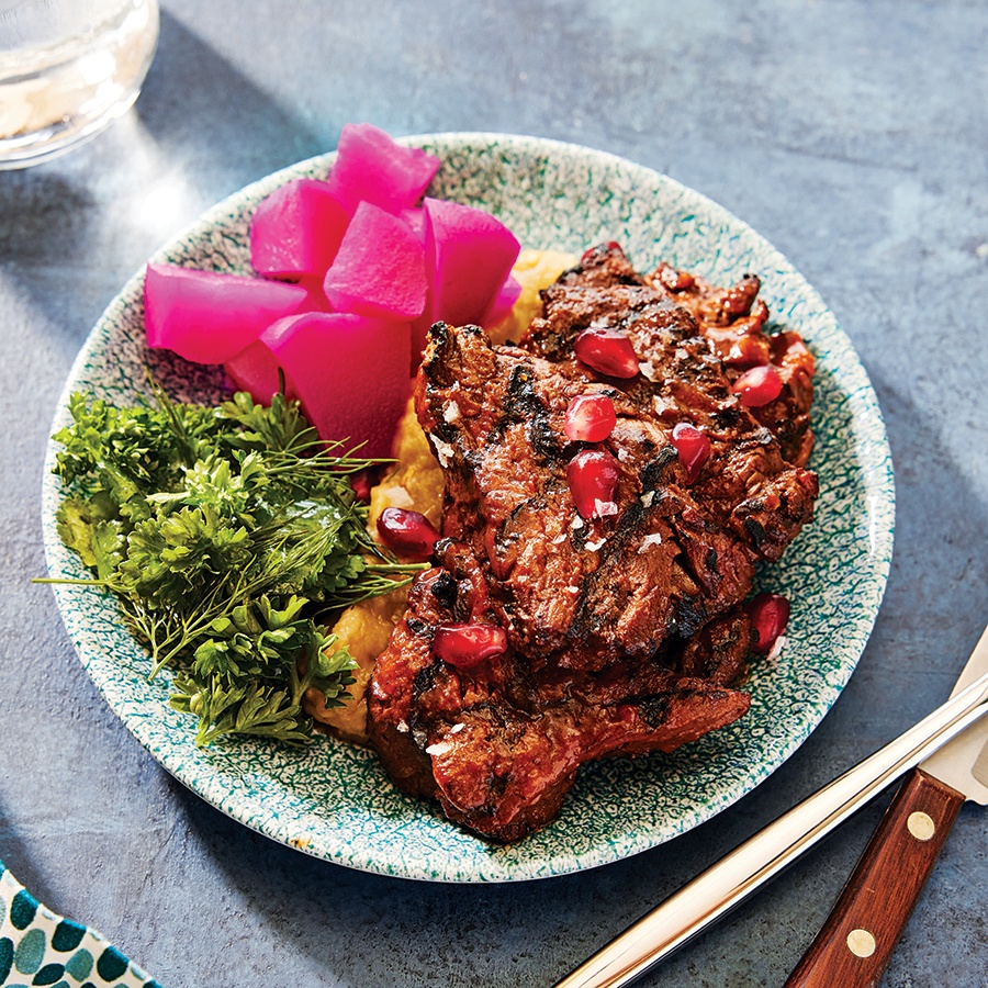 Steak tips are topped with pomegranate seeds and a side of bright pink pickled turnips.