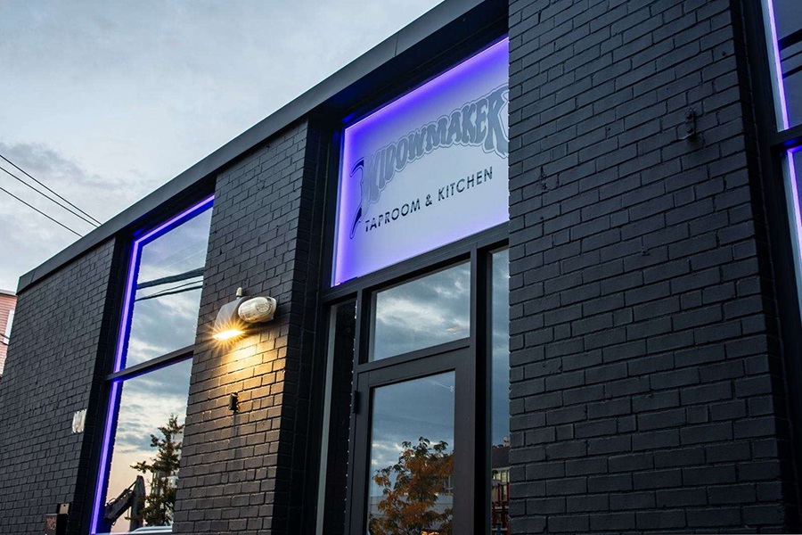 Exterior of a taproom with bricks painted black.