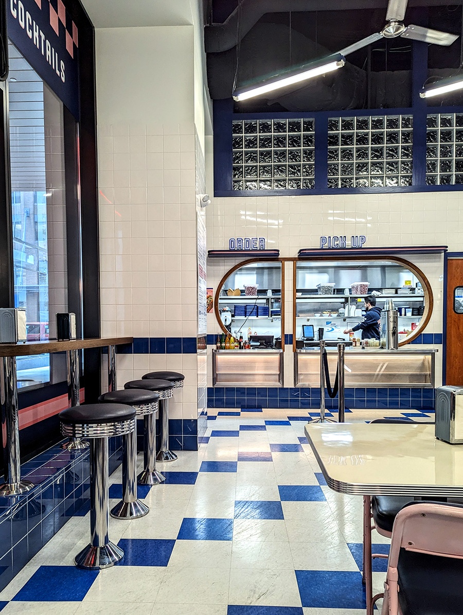 A casual taqueria has white subway tiles and white-and-blue tiled floor.