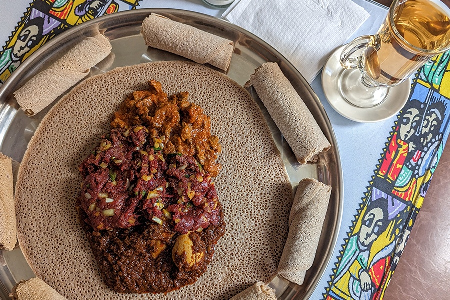 Overhead view of Ethiopian meats on injera.